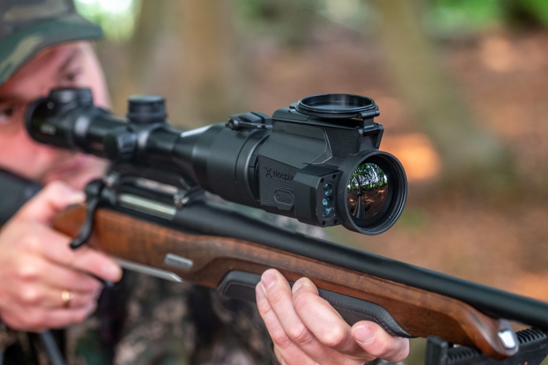 Ein Mann benutzt einen Wärmebildaufsatz an der Vorderseite zum Zielen.