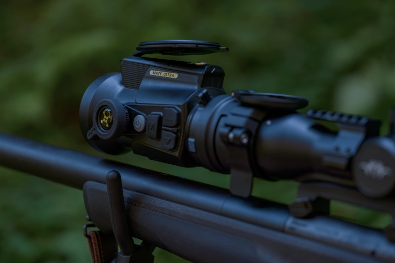 Nahaufnahme des MATE ULTRA Zielfernrohrs auf einem Gewehr vor grünem Hintergrund