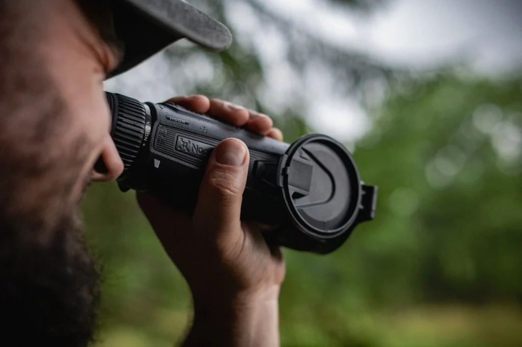 Jaeger beobachtet mit einem Waermebildgeraet der Nocpix VISTA Serie im Waldrevier.