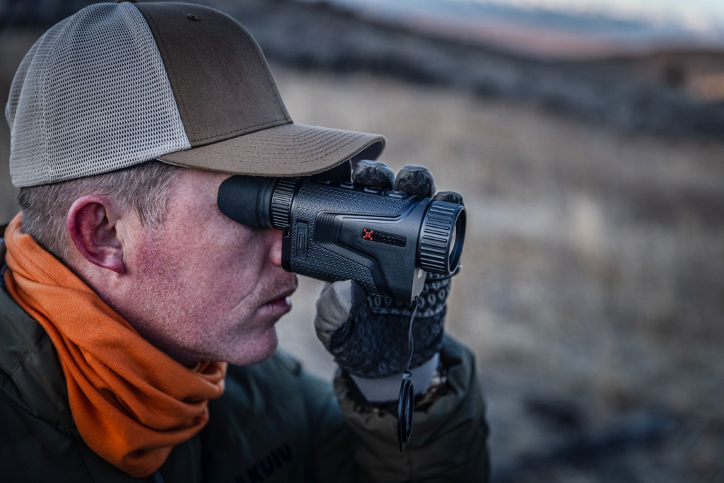 Närbild av en jägare som använder en handhållen monokikare utomhus.
