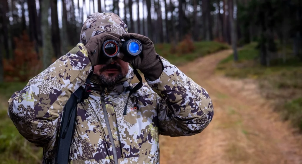 Man using Nocpix QUEST thermal binoculars for outdoor hunting observation