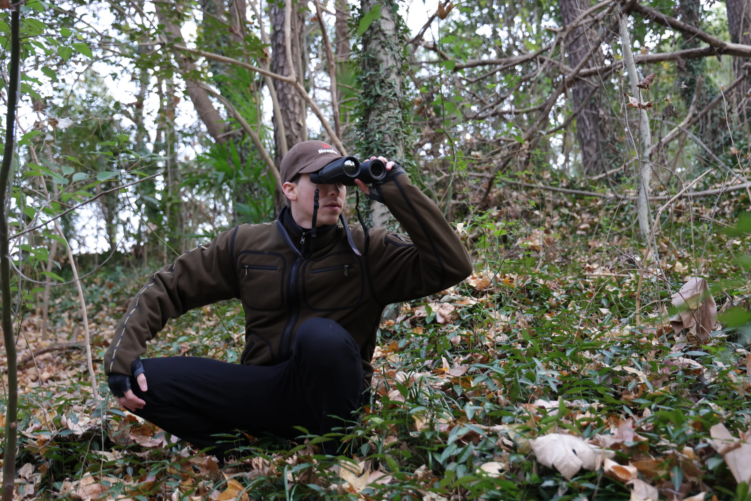 Hunter in a low stance observing wildlife, showing comfortable observation posture