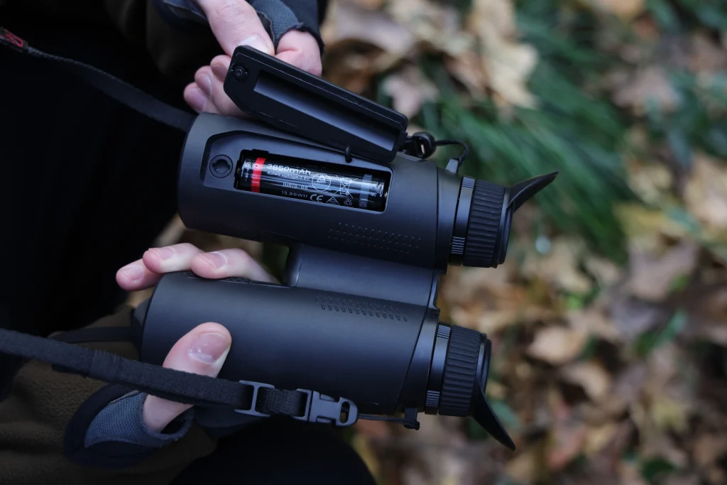 Thermal binoculars close-up highlighting buttons and removable battery compartment